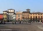 A Piazza Bra  maior praa de Verona e seu nome  originrio do termo braida que, por sua vez, deriva do alemo breit, ou seja, largo, amplo, um vasto espao. E de fato  uma praa grande e abriga diversos palcios, casas e monumentos de pocas muito diferentes entre si, desde a Antigidade Romana at o sculo XIX.  esquerda da praa, para quem chega dos Portoni della Bra, vemos o Teatro Filarmonico, cuja construo iniciou-se em 1716 e concludo somente em 1729, sendo destrudo quase completamente durante a II Grande Guerra e reconstrudo de acordo com o projeto inicial. Do outro lado da rua, vemos fileiras de casas coloridas com toldos verdes que abrigam restaurantes e bares de pblico mais seleto, ao centro, uma grande rvore e um pequeno chafariz, ao fundo, a imponente Arena, um dos smbolos da cidade e herana dos nossos ancestrais romanos,  direita, o edifcio do Municpio de Verona e o Palazzo della Gran Guardia, construdo no incio de 1610 e concludo na metade do sculo XVIII. <br><br/> Palavras-chave: Itlia, arquitetura, Verona, arte renascentista.