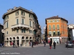 A Piazza Bra  maior praa de Verona e seu nome  originrio do termo braida que, por sua vez, deriva do alemo breit, ou seja, largo, amplo, um vasto espao. E de fato  uma praa grande e abriga diversos palcios, casas e monumentos de pocas muito diferentes entre si, desde a Antigidade Romana at o sculo XIX.  esquerda da praa, para quem chega dos Portoni della Bra, vemos o Teatro Filarmonico, cuja construo iniciou-se em 1716 e concludo somente em 1729, sendo destrudo quase completamente durante a II Grande Guerra e reconstrudo de acordo com o projeto inicial. Do outro lado da rua, vemos fileiras de casas coloridas com toldos verdes que abrigam restaurantes e bares de pblico mais seleto, ao centro, uma grande rvore e um pequeno chafariz, ao fundo, a imponente Arena, um dos smbolos da cidade e herana dos nossos ancestrais romanos,  direita, o edifcio do Municpio de Verona e o Palazzo della Gran Guardia, construdo no incio de 1610 e concludo na metade do sculo XVIII. <br><br/> Palavras-chave: Itlia, arquitetura, Verona, arte renascentista.