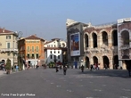 A Piazza Bra  maior praa de Verona e seu nome  originrio do termo braida que, por sua vez, deriva do alemo breit, ou seja, largo, amplo, um vasto espao. E de fato  uma praa grande e abriga diversos palcios, casas e monumentos de pocas muito diferentes entre si, desde a Antigidade Romana at o sculo XIX.  esquerda da praa, para quem chega dos Portoni della Bra, vemos o Teatro Filarmonico, cuja construo iniciou-se em 1716 e concludo somente em 1729, sendo destrudo quase completamente durante a II Grande Guerra e reconstrudo de acordo com o projeto inicial. Do outro lado da rua, vemos fileiras de casas coloridas com toldos verdes que abrigam restaurantes e bares de pblico mais seleto, ao centro, uma grande rvore e um pequeno chafariz, ao fundo, a imponente Arena, um dos smbolos da cidade e herana dos nossos ancestrais romanos,  direita, o edifcio do Municpio de Verona e o Palazzo della Gran Guardia, construdo no incio de 1610 e concludo na metade do sculo XVIII. <br><br/> Palavras-chave: Itlia, arquitetura, Verona, arte renascentista.